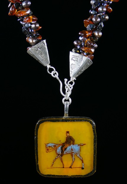 “Ambling Along Silver & Beadwork Necklace” Pendant: 1.5" square, Overall length: 18", Price: $650, Chisholm Ref #: SBW-N1 - This one-of-a-kind, beaded necklace is made of amber, freshwater pearls, fire polished Czech crystals, and Japanese square & ring shaped glass beads. The handmade silver bead caps show the imprint of many warmblood breed logos. The focal piece is a hand-painted, fused glass pendant featuring a relaxed rider ambling along.