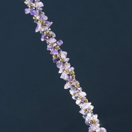 “Amethyst Dream Bracelet” Overall Length 8.75", Price: $329, Chisholm Ref. #: SB-108 - One of a kind beaded bracelet woven with amethyst, glass, and Czech crystal beads. The end caps have a swirling texture, the toggle clasp bears the warmblood breed logos, and the closure is set with two garnets cabuchons. Findings are hancrafted in .960 silver.