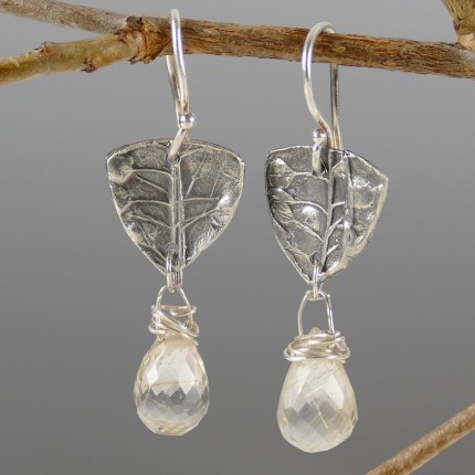 “Citrine Drop Earrings” Overall Lemgth: 1.5", Price: $189, Chisholm Ref. #: SE7 - Faceted citrines hang from pieces of silver textured with wildflower seed pods. Earrings are hand crafted in .960 silver. Ear wires are sterling silver (.925).