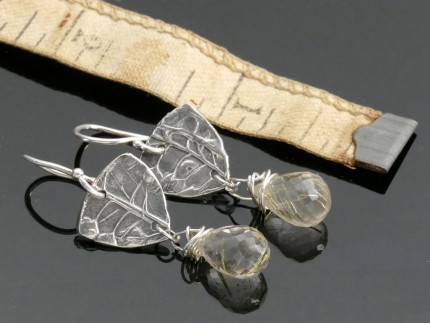 “Citrine Drop Earrings” Overall Lemgth: 1.5", Price: $189, Chisholm Ref. #: SE7 - Faceted citrines hang from pieces of silver textured with wildflower seed pods. Earrings are hand crafted in .960 silver. Ear wires are sterling silver (.925).