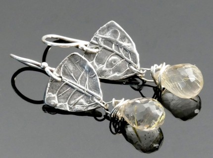 “Citrine Drop Earrings” Overall Lemgth: 1.5", Price: $189, Chisholm Ref. #: SE7 - Faceted citrines hang from pieces of silver textured with wildflower seed pods. Earrings are hand crafted in .960 silver. Ear wires are sterling silver (.925).