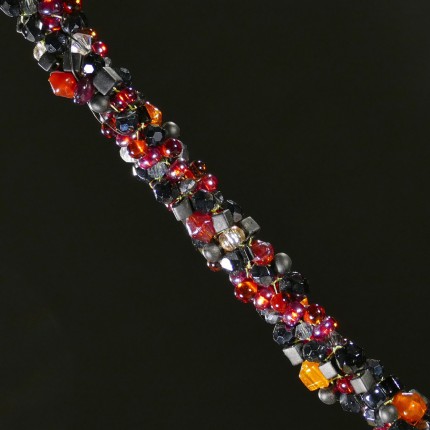 “Flying Horse Beaded Necklace” Overall length: 28.5", Flying Horse Pendant: 1" Diameter, Price: $600, Chisholm Ref. #: SBW-N4 | This one-of-a-kind silver & beadwork necklace woven using vintage glass beads and crystals, Czech fire polished crystals, and Japanese toho beads in shades of reds, orange and black. The end-caps are textured with warm blood breed logos. The focal piece features the classic Han Flying Horse. The findings are all handcrafted in .960 silver.