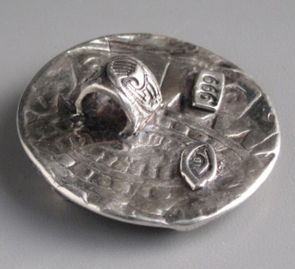 “Longchamps” 1.125" diameter, Price: $199, Chisholm Ref. #: S-SH3 - Racing afficianados will recognize this pendant as a tribute to Longchamp Racecourse, located on the banks of the Seine River in Paris. The high relief iinvites you to step into the scene, with the grandstands in the background and the horse and his groom in the foreground. The word "Longchamps" is visible on the lower part of the pendant, although it is hard to capture in photographs. Hand crafted in .960 silver.