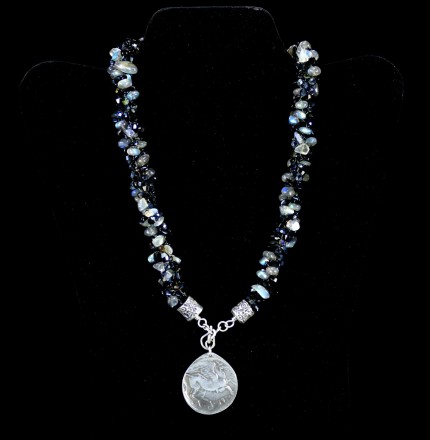 “Pegasus Blue Glow Silver & Beadwork Necklace” Pendant: 1.25" diameter, Overall length: 21", Price: $650, Chisholm Ref. #:SBW-N7 - This one-of-a-kind silver & beadwork necklace is made of labradorite, jet, and Czech fire polished crystals. The handmade silver end-caps are deeply textured. The focal piece of the necklace is a large, Pegasus pendant modeled on a Greek coin. The reverse of the pendant is impressed with the pattern of a real feather. Handcrafted in .960 silver.