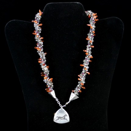 “Triple Luck Beaded Necklace” Overall length: 19", Pendant: 1.25" x 1.25", Price: $550, Chisholm Ref. #: SBW-N11 | One-of-a-kind silver & beadwork necklace made of freshwater pearls, Czech fire polished crystals, Czech glass dagger beads, and glass seed beads. The handmade, silver end-caps are textured with a motif of warmblood breed logos. The focal piece of the necklace is a convex, triangular pendant with the dramatic silhouette of a running horse. The findings are all handcrafted in .960 silver.
